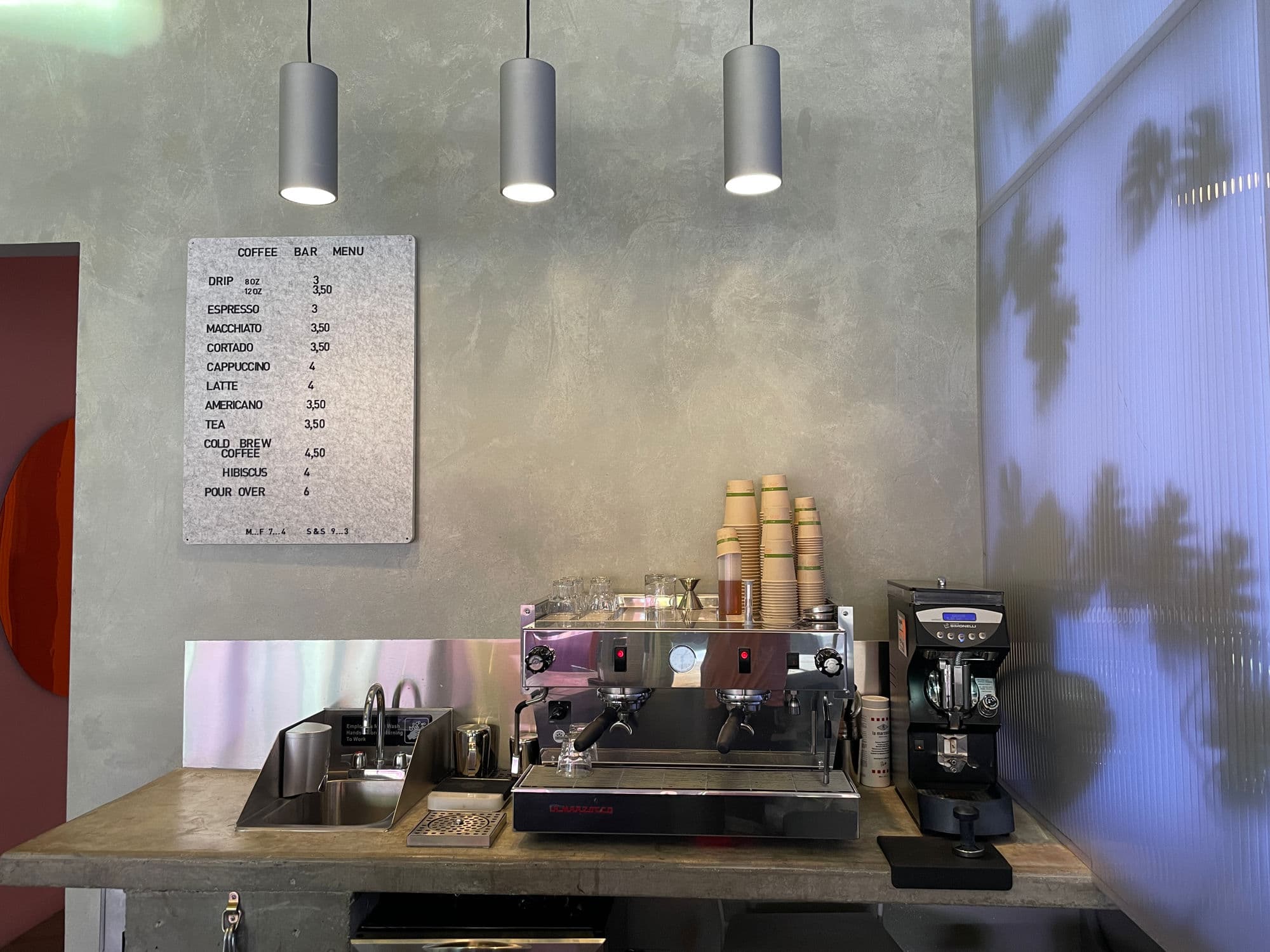 The Wandering Barman café counter with espresso machine and concrete walls
