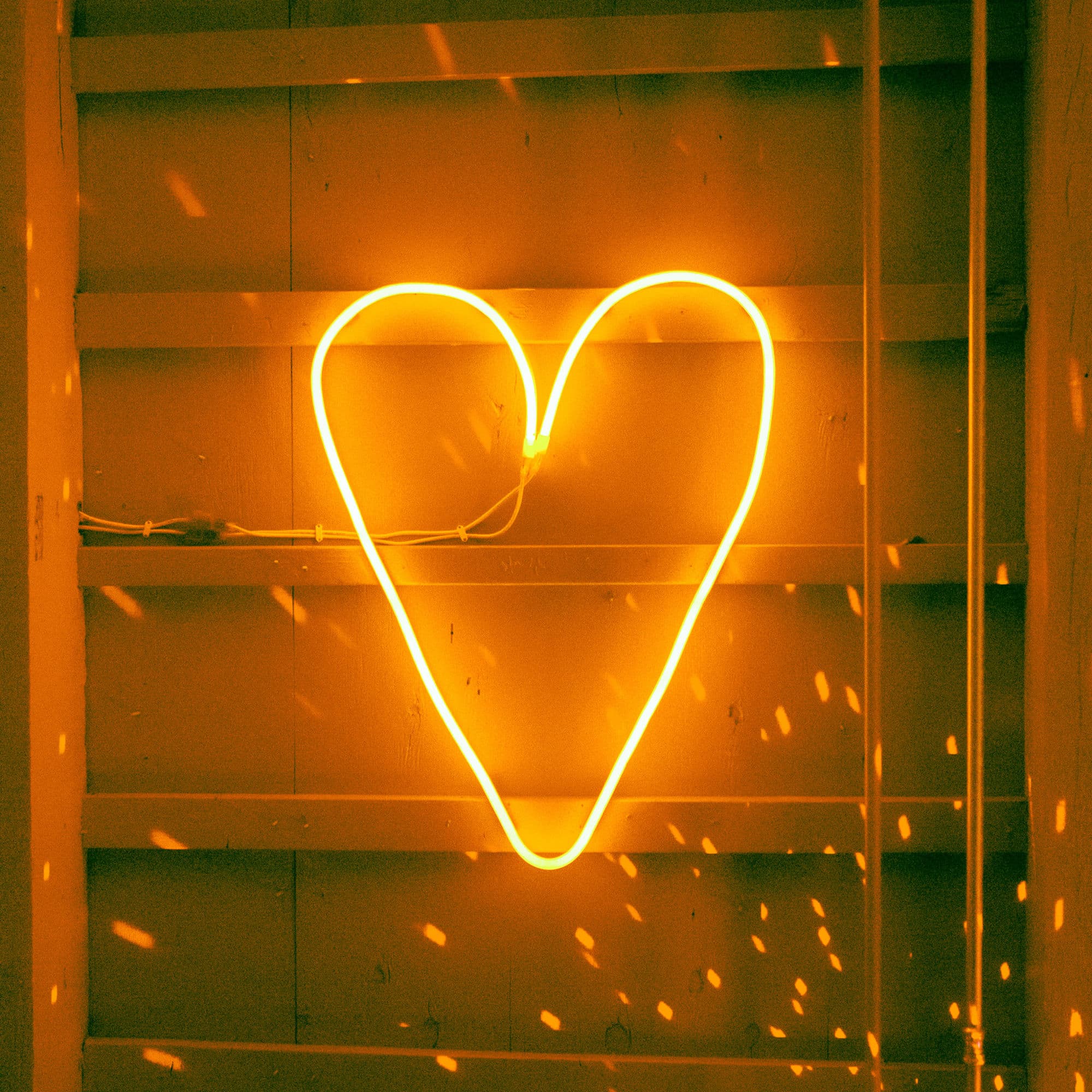 Neon heart sign in warm orange glow