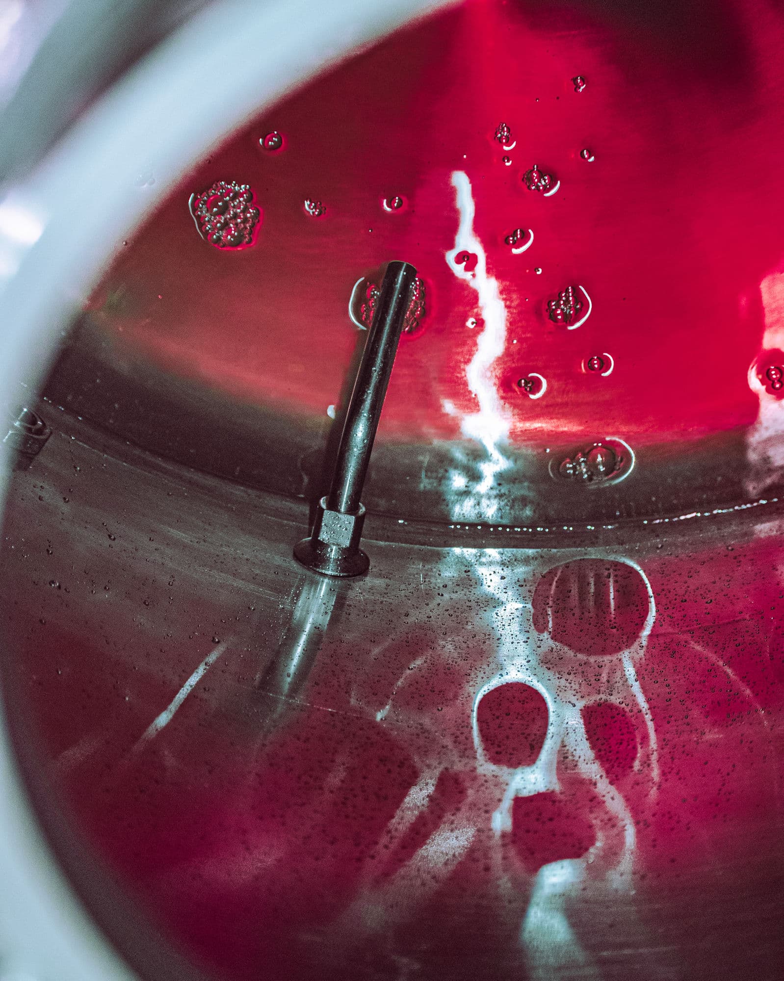 Crimson cocktail base being mixed in a stainless steel vat